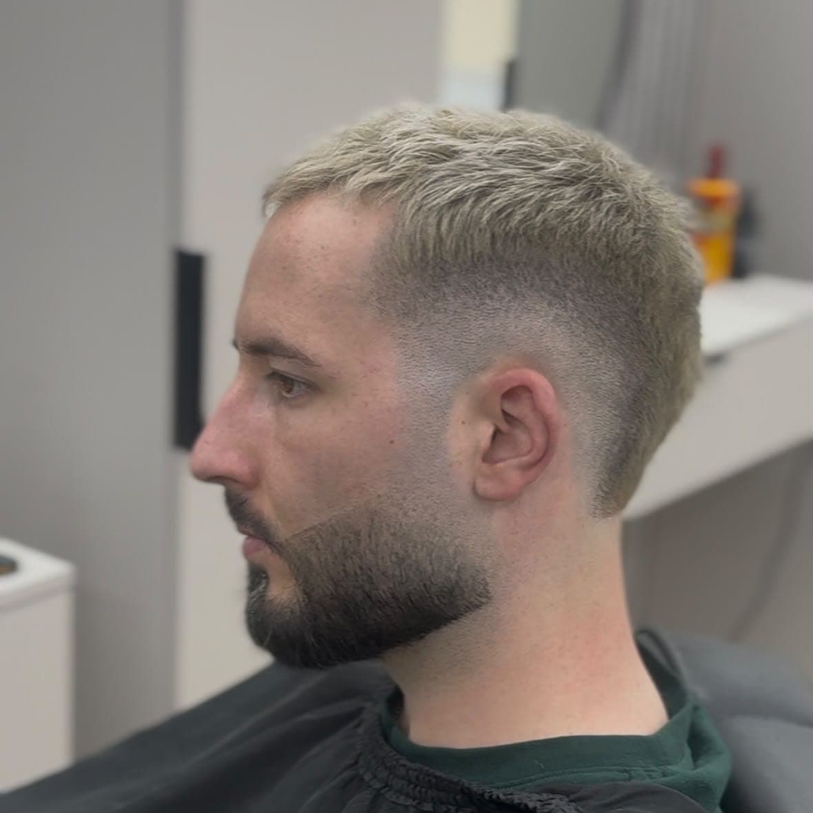 Tuns scurt blond, cu fade la mijloc și barbă conturată